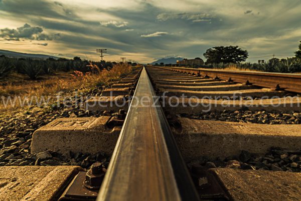 Vias de tren cielo nublado. Sobre via campo tequilero.